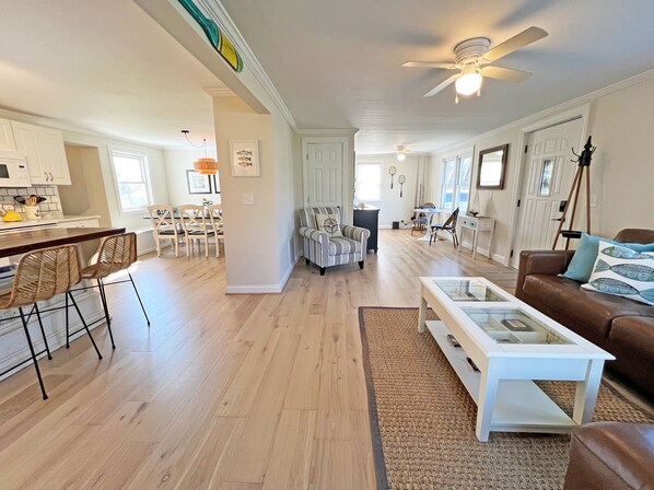 A spacious living area with a kitchen, dining area, and a cozy seating space with a couch and chairs.