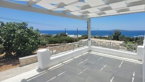 Ein Balkon im Freien mit freiem Blick auf das Meer und einer weißen Pergola.