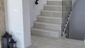 Ein geräumiger Innenraum mit einer Treppe, die zu einer oberen Etage führt.