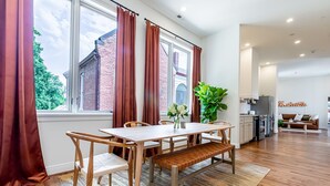 Eine moderne Küche mit Backofen und einem Essbereich mit Holztisch und Stühlen.