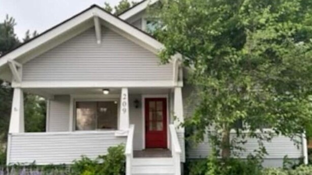 A single-story house with a front porch, a red door, and a number '209' on the wall. - Spacious charming farmhouse-style home - dedicated office (Burlington)