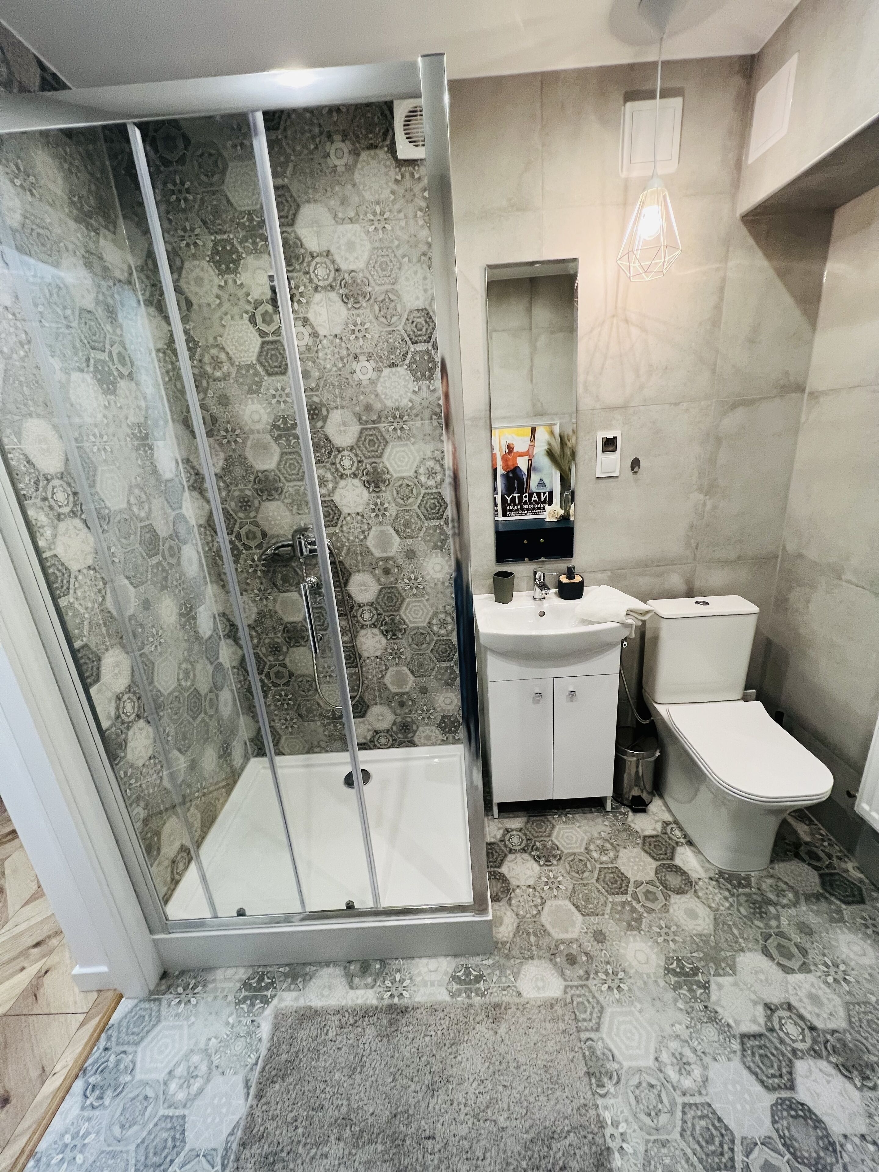Une salle de bain avec douche, toilettes et lavabo.