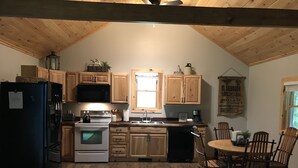 A kitchen with wooden cabinets, a refrigerator, a microwave, an oven, and a sink. - Whitetail Hollow  (McBain)