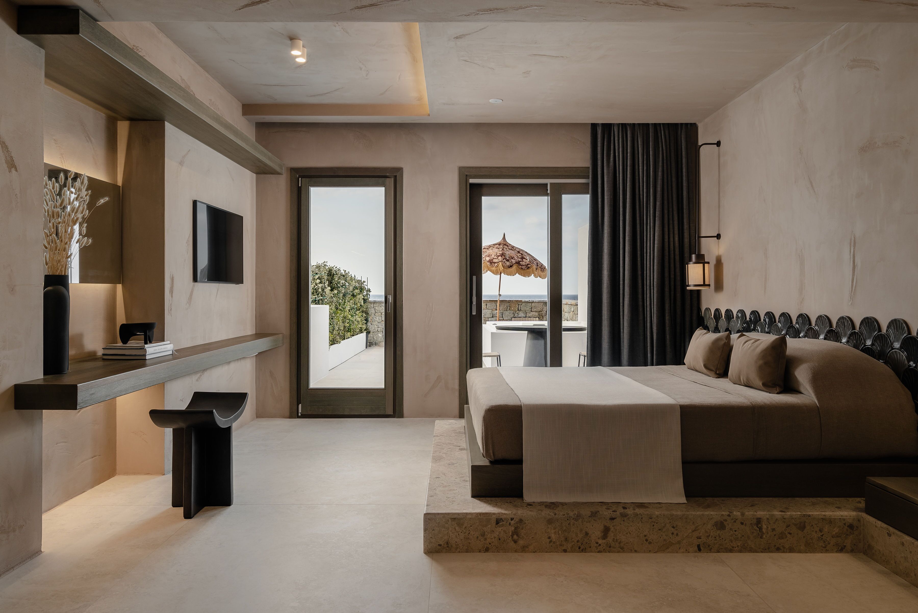Une chambre moderne dotée d’un grand lit, d’un téléviseur à écran plat, d’une petite table et offrant une vue sur l’extérieur.