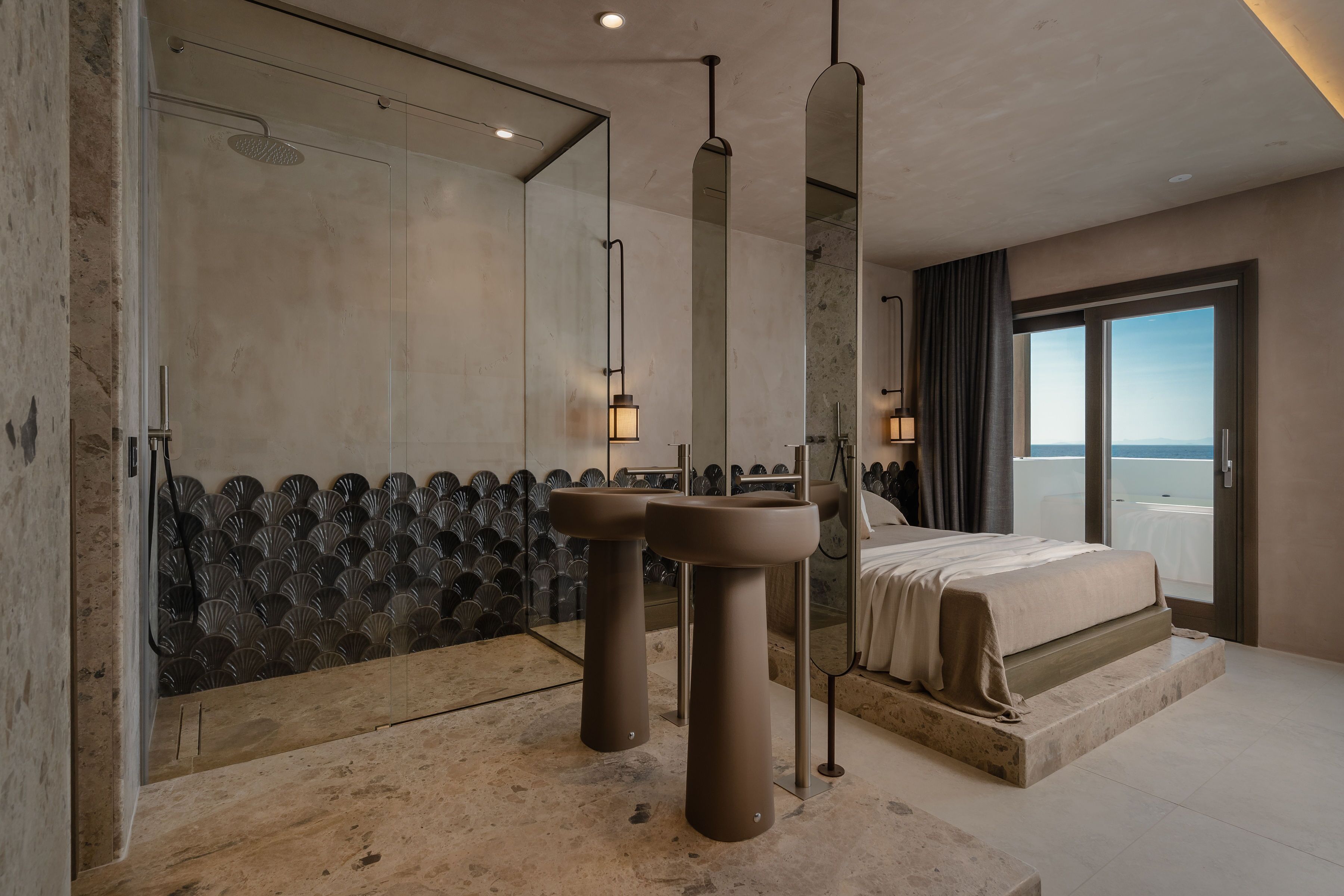 Un baño moderno con cabina de ducha de vidrio, dos lavamanos pedestal y un espejo grande.