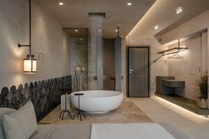 Un baño moderno con una amplia bañera independiente, un perchero de pared y un diseño minimalista.