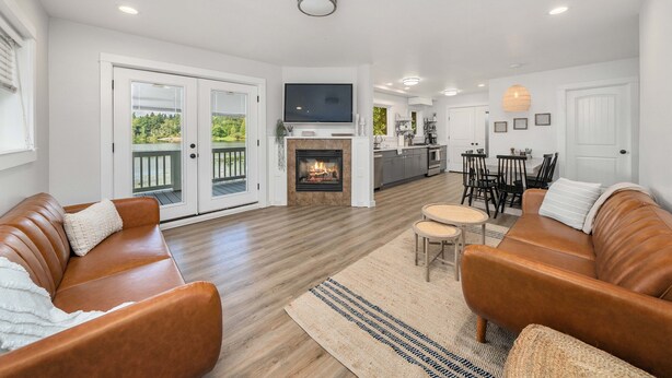 A spacious living room with a fireplace, a TV mounted above it, and a dining area with a bar.