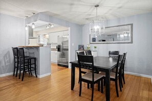 Enjoy meals in the spacious kitchen and dining area, featuring a central island and a dining table with matching chairs.