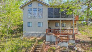 A two-story house with a wooden deck and a staircase leading to a porch. - Lakeside Dreaming! 2b-2b, Sleeps 6, Lake of the Ozarks. (Gravois Mills)