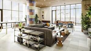Uma sala de estar moderna com um sofá seccional, uma mesa de centro e um espaço de jantar com cadeiras.