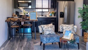 A modern kitchen with dark cabinetry, stainless steel appliances, and a dining area with a wooden table and chairs. - Villa on the Rock ~ Luxury vacation rental near beach with Roof top lounge area (Trelawny)