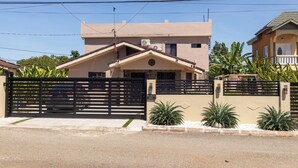 A residential building with a gated entrance, air conditioning units, and a well-maintained garden. - Villa on the Rock ~ Luxury vacation rental near beach with Roof top lounge area (Trelawny)