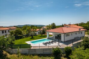 A villa with a swimming pool, a covered patio, and a view of the surrounding landscape. - NEW villa with pool for 4 persons near Labin, Istria (Labin)