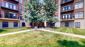 A multi-story building with a central courtyard, a tree, and a signpost. - 2 bed/2 bath Condo - Less than 1 Mile to Broadway! (Nashville)
