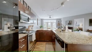A modern kitchen with granite countertops, stainless steel appliances, and wooden cabinets. - 2 bed/2 bath Condo - Less than 1 Mile to Broadway! (Nashville)