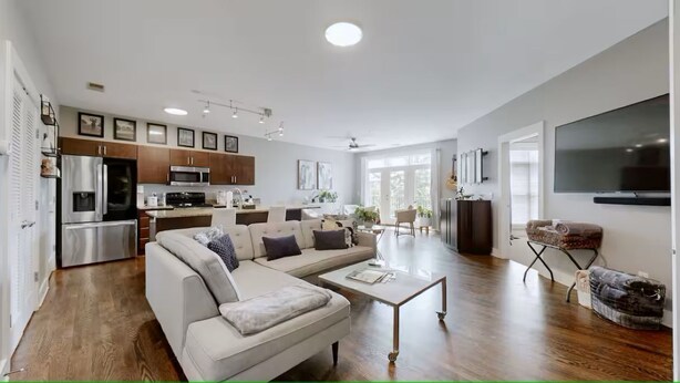 A modern living room with a sectional sofa, a coffee table, and a flat-screen TV. - 2 bed/2 bath Condo - Less than 1 Mile to Broadway! (Nashville)