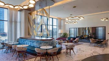 A modern lounge area with seating arrangements, including sofas and chairs, and a central decorative structure.
