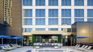 A modern hotel with a rooftop pool, sun loungers, and a bar area. - Tempo By Hilton Nashville Downtown (Nashville)