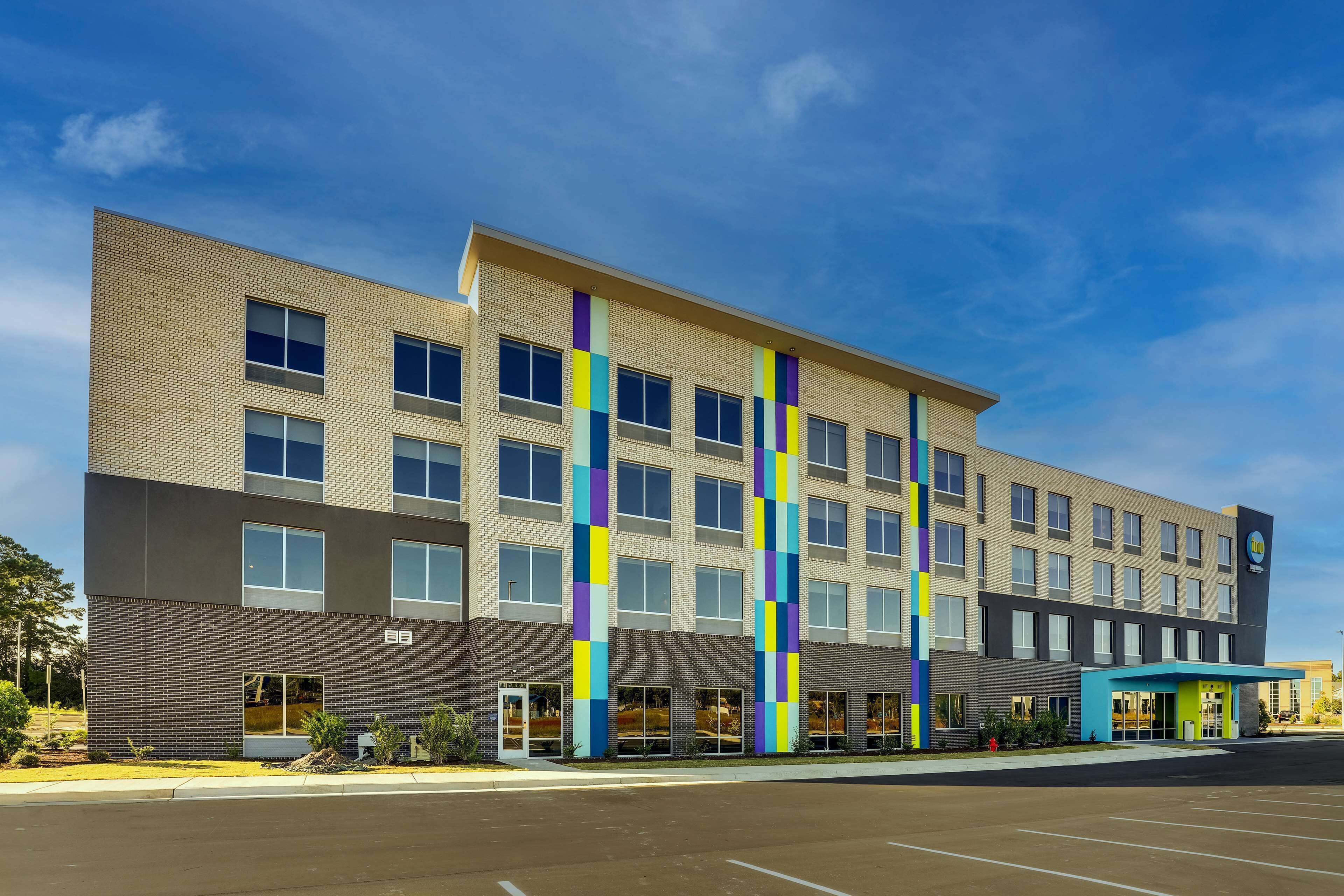 A multi-story hotel with a modern design, featuring a brick facade and large windows.