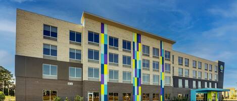 A multi-story hotel with a modern design, featuring a brick facade and large windows.