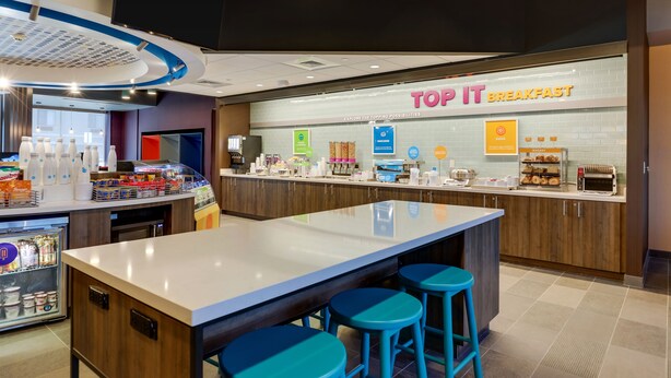 Un espace dédié au petit-déjeuner, comprenant un comptoir, des tabourets et une variété d'aliments.