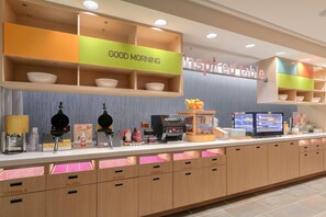 A breakfast bar with a 'Good Morning' sign, a coffee machine, and a fruit display. - Home2 Suites By Hilton Alcoa Knoxville Airport (Alcoa)