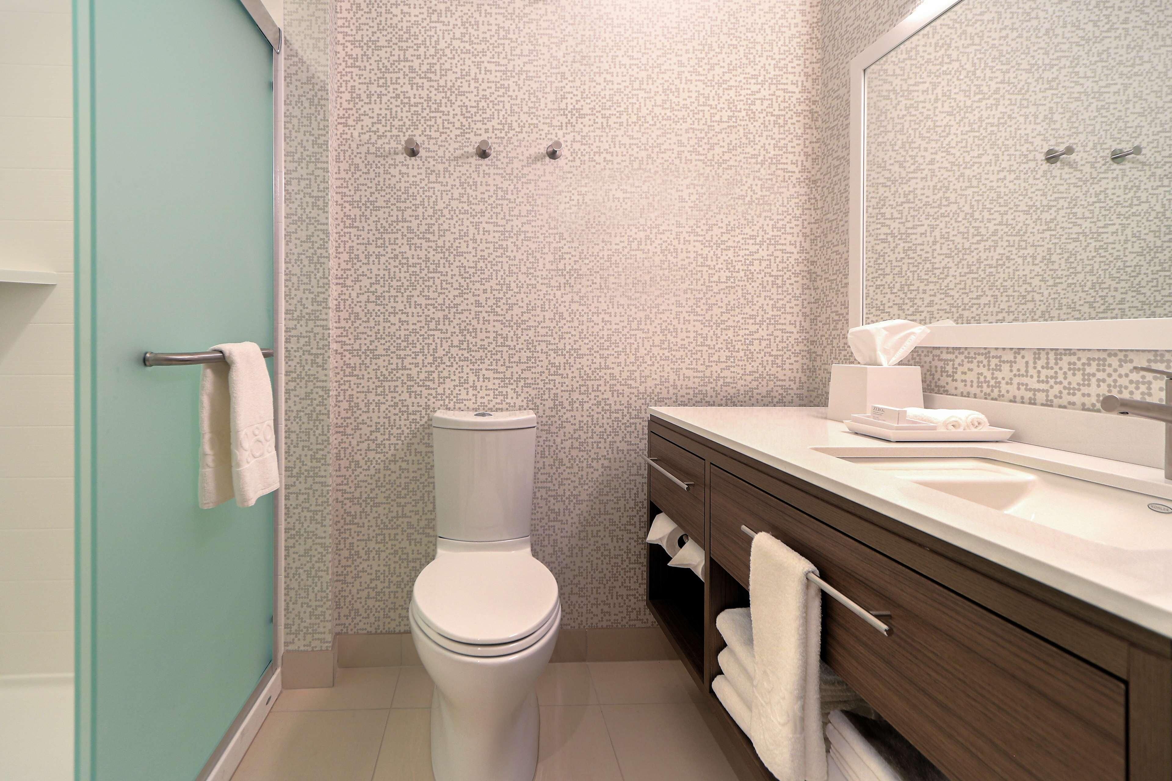 A modern bathroom with a toilet, sink, and vanity.