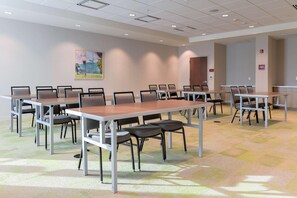 A conference room with multiple tables and chairs, carpeted flooring, and a painting on the wall. - Home2 Suites By Hilton Alcoa Knoxville Airport (Alcoa)