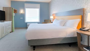 Une chambre d’hôtel avec un lit, un bureau, une chaise et un téléviseur.