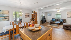 A spacious living room with a dining area, wooden furniture, and artwork on the walls. - Open Water~Sunsets~Swimming~Standing Work Station with High Speed Internet~Lake (Mabank)