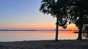 A sunset view over a calm lake with a tree in the foreground. - 1 bedroom awesome home in Hörby (Hörby)
