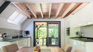 Una cocina moderna con comedor, con un amplio ventanal corredero que da a un jardín.