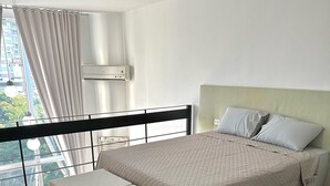A modern bedroom with a bed, a bench, a balcony, and a city view. - Saint Sebastian 307 Duplex no Centro. (Jaragua do Sul)