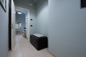 Un couloir avec une valise, un bureau et une chaise.