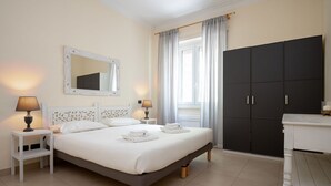 Un dormitorio con cama, lámparas de noche, armario y espejo.