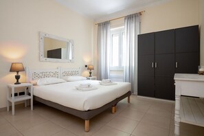 A bedroom with a bed, bedside lamps, a wardrobe, and a mirror. - Olimpico Apartment Flaminio (Roma)