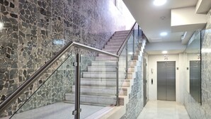 Ein modernes Interieur mit einer Marmortreppe, Metallgeländern und einem sauberen, gefliesten Boden.