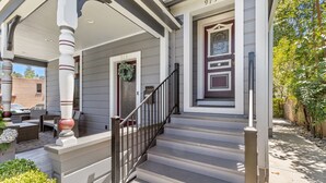 A two-story house with a porch, a staircase, and a front door marked with the number 973. - The McCann House Downtown Auburn 2 (Auburn)