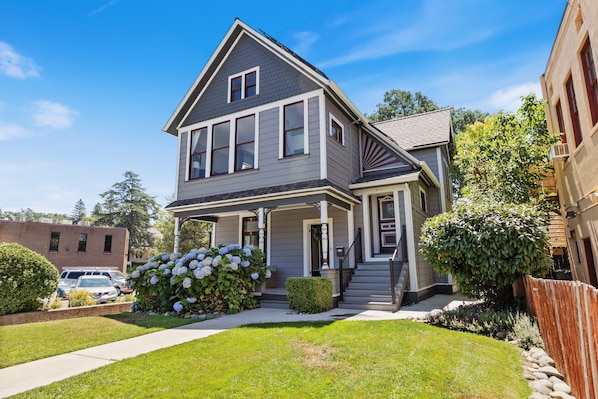 A two-story house with a front porch, a garage, and a well-maintained lawn.