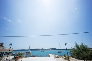 A waterfront view with boats, a gazebo, and a building with a chimney.