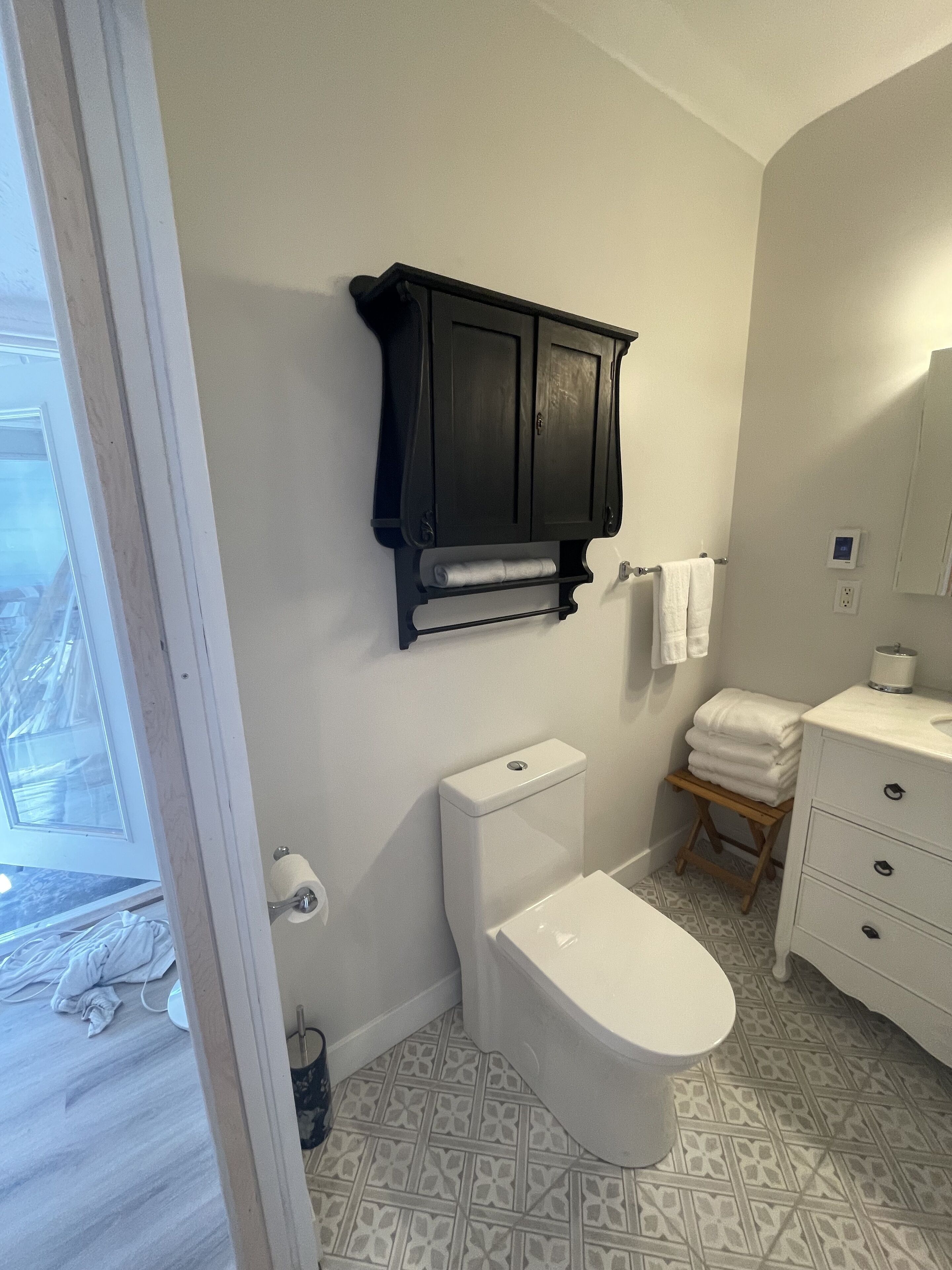 Un bagno con il water, un lavandino, uno specchio e un porta asciugamani.