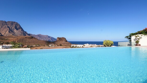 Ein klares, blaues Schwimmbecken mit Bergblick und Meerblick.