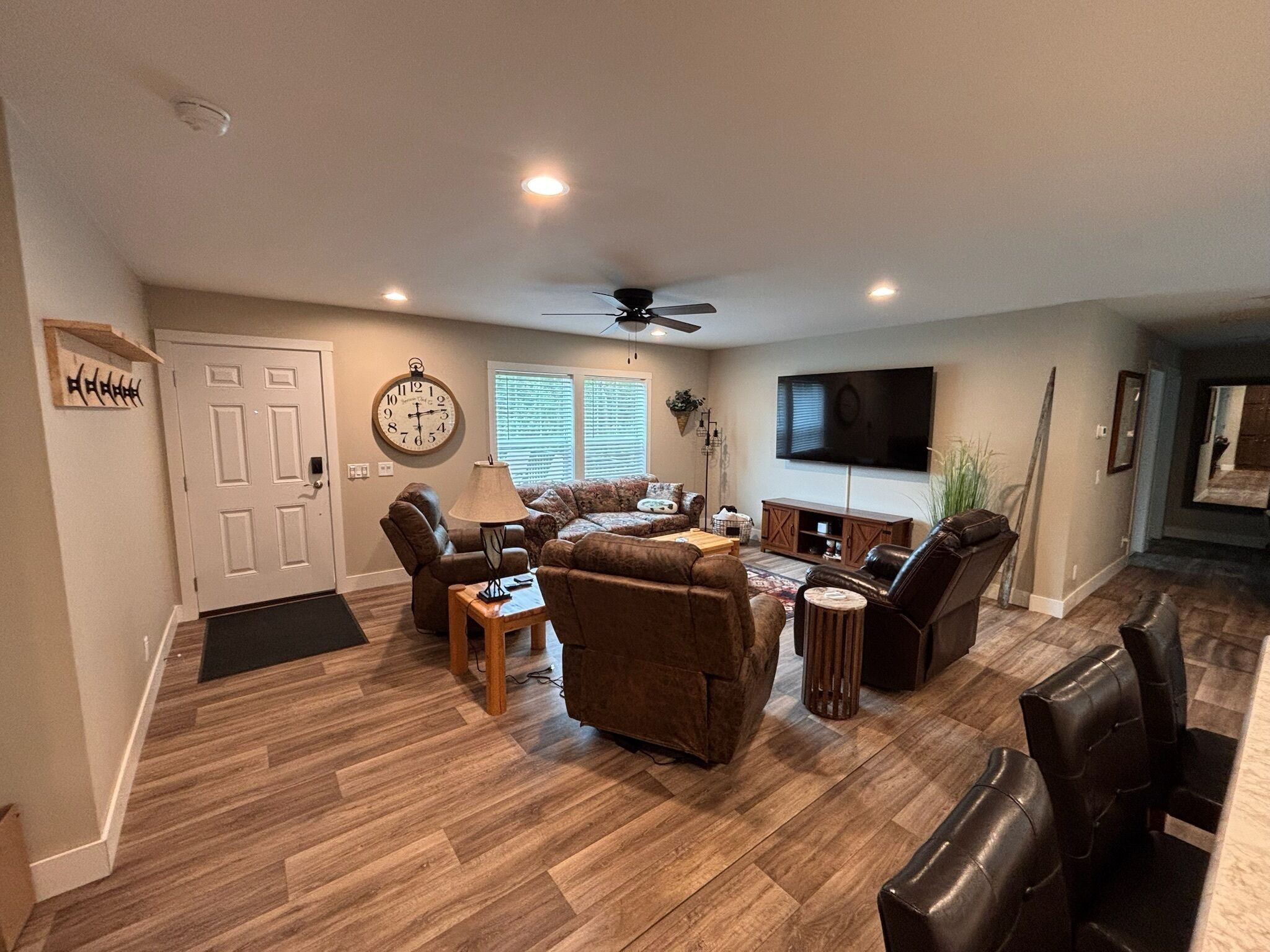 A spacious living room with a fireplace, a television, and a ceiling fan.