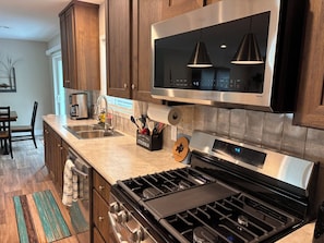 A modern kitchen with stainless steel appliances, wooden cabinets, and a built-in oven.