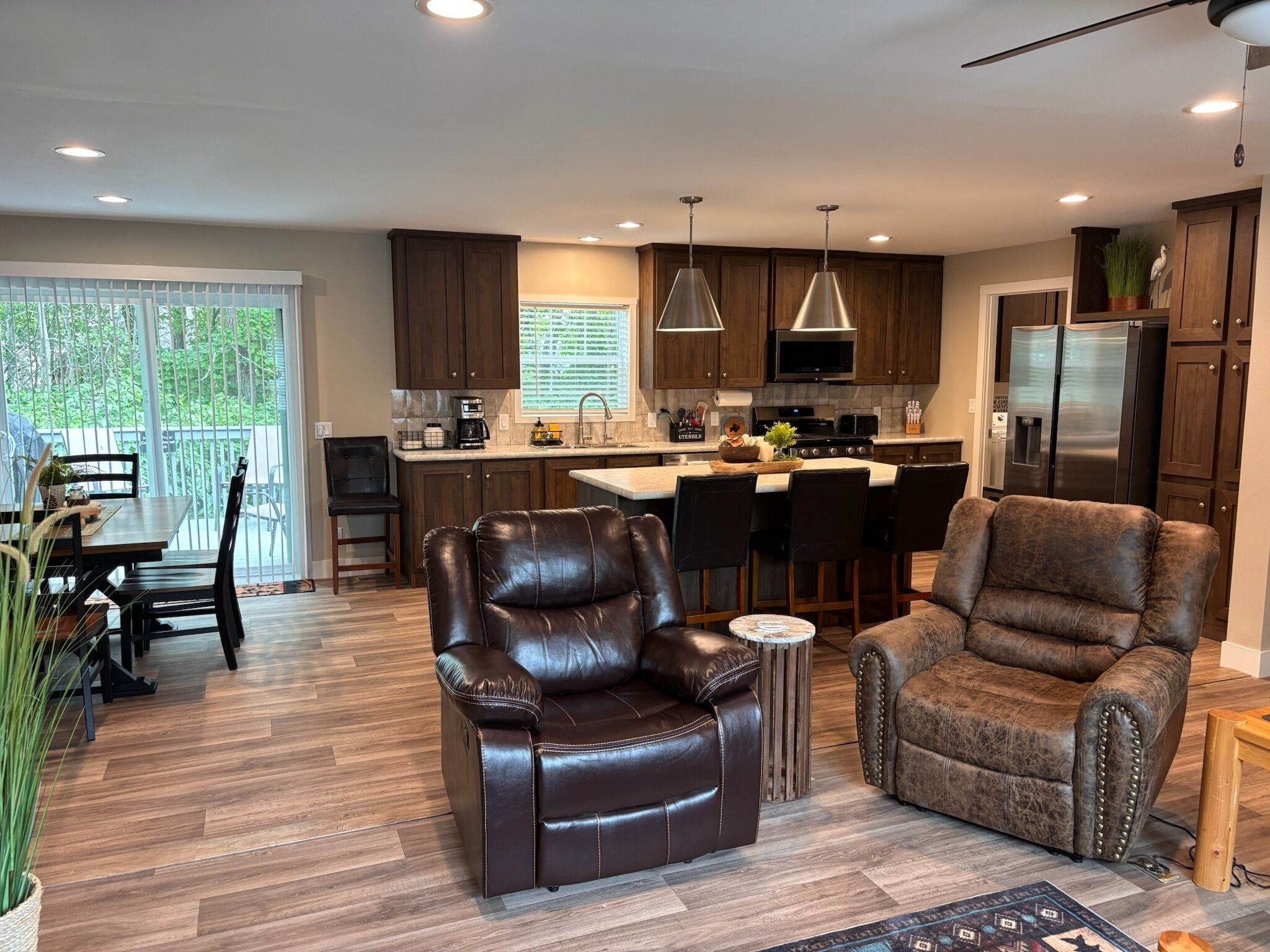 A modern kitchen with dark wood cabinets, stainless steel appliances, and a central island.