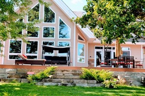 Relax in the covered patio area with outdoor furniture, or unwind on the bench amidst the stone retaining wall.
