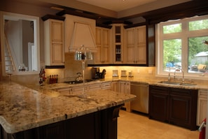 Enjoy cooking in this well-equipped kitchen with a central island, cabinetry, and large window.