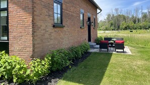 A brick building with a patio area featuring outdoor furniture.