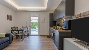 Een moderne keuken met een eethoek, een flatscreen televisie en uitzicht.