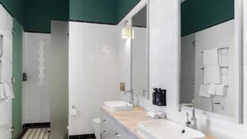 A modern bathroom with two sinks, a large mirror, and a patterned floor.